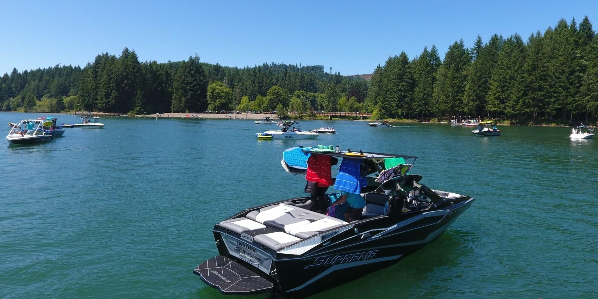A group of people on a Supreme boat in the middle of a lake.