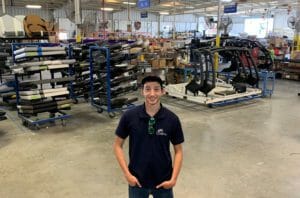 A young man standing among bicycles in a warehouse.