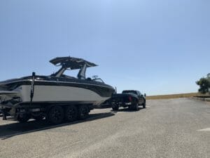 Supreme Boats being loaded onto a trailer in a parking lot.