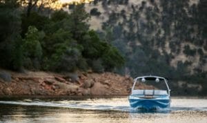 Wake surfing boat cruising slow across lake