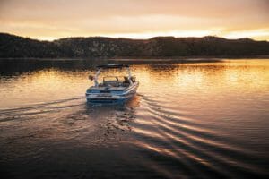 A Supreme boat on a lake at sunset.