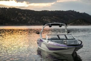A Supreme boat sits on a lake at sunset.