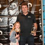 A man and a little girl posing for a picture with Supreme Boats in the background.