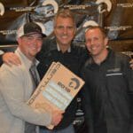 Three men posing for a picture with a Supreme sign.