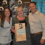 Three people standing in front of a banner at the Supreme Boats event.