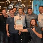 A group of men posing with a Supreme Boats plaque.