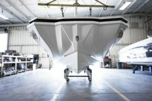 A white boat is sitting in a garage; supreme.