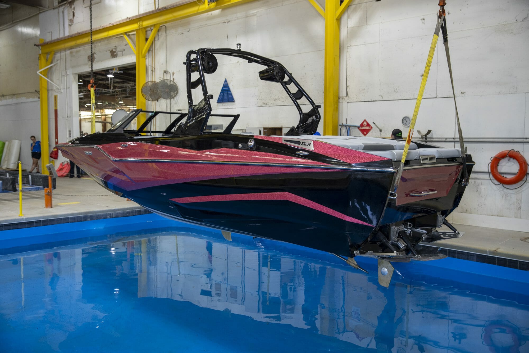 A Supreme wakeboard boat hanging in a garage.
