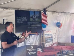 A man giving a speech in front of a Supreme tent.