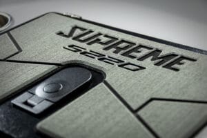 Close-up of a textured panel with embossed "Supreme S220" text and a black latch or handle below, highlighting the premium finish of the Supreme Towboats S220.