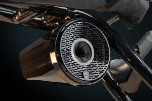 Close-up of a black, cylindrical Supreme S220 speaker with a metal honeycomb-style cover and a small logo at the bottom.