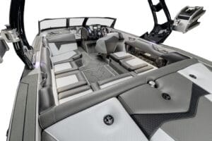 Interior view of the Supreme S220 motorboat featuring cushioned seating, a sleek gray and black design, and high-tech controls at the helm.