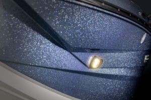 Close-up of the front section of a Supreme S240 blue boat with a metallic, glittery finish and a small illuminated yellow light.