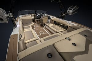 Interior view of a modern Supreme S240 speedboat featuring tan and brown cushioned seating, a central cockpit, and integrated storage compartments.