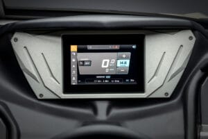 Close-up of a digital dashboard display showing speed, battery percentage, and other vehicle information inside a modern Supreme S240 boat interior.