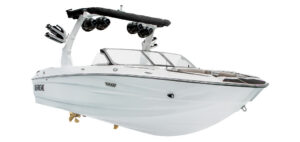 A white Supreme Towboats S220 motorboat with a black wakeboard tower, multiple speakers, and seating visible at the front and rear.
