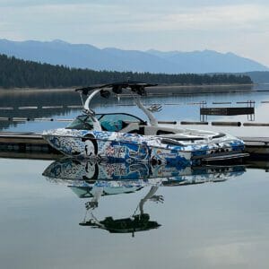 A Supreme boat docked on a serene lake with majestic mountains in the background.