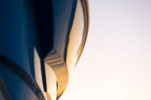 Close-up of a sleek, abstract surface with smooth curves and reflective, glossy features on the Supreme S240. The background is softly lit, creating a minimalist and modern visual effect.