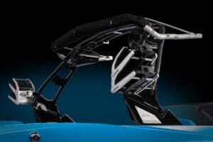 Close-up of a sleek blue Supreme S240 featuring a modern wakeboard tower with several metallic and padded components. The background is black, highlighting the boat's design details.