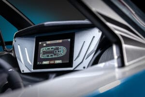 Close-up of a car dashboard featuring a digital display showing a vehicle diagram with system warnings and alerts, reminiscent of the advanced monitoring systems found in the Supreme Boats S240.