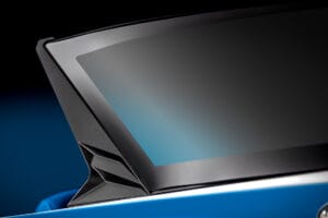 Close-up of the rear corner of a modern car window with a sleek design, showcasing a black trim and a blue body in the background—reminiscent of the seamless elegance found in Supreme Boats S240.
