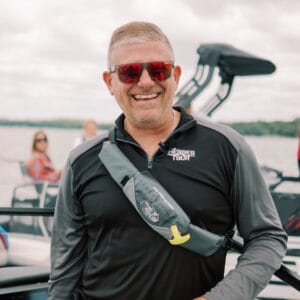 Jeremy smiles while standing on a boat.