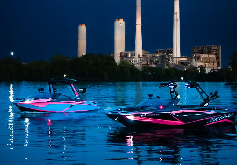 Experiencing the transformative power of water sports as two jet skis navigate the night near a power plant.