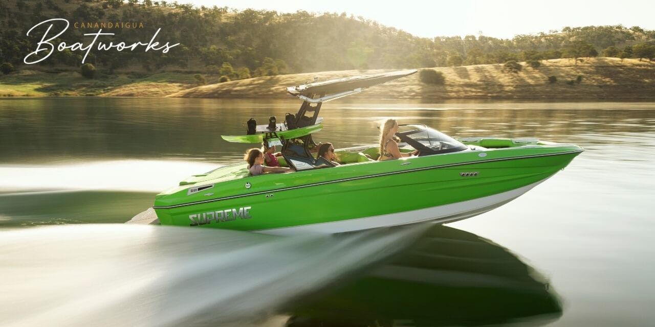 A bright green speedboat from Centurion Boats, with four passengers, moves swiftly across a calm lake with hills in the background.