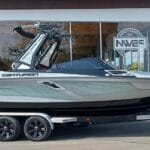 A sleek Centurion boat on a trailer parked outside a showroom with glass windows and signage, ready for transport.