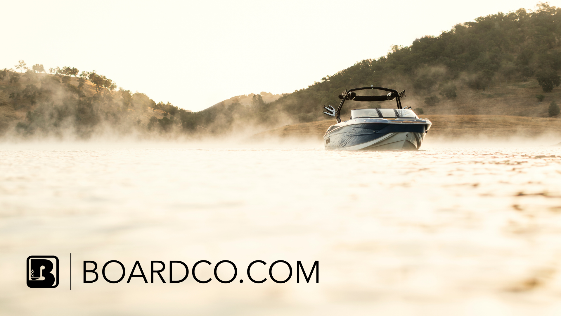 A motorboat from Centurion Boats floats on a misty lake with hills in the background; BOARDCO.COM logo and text appear in the lower left corner.